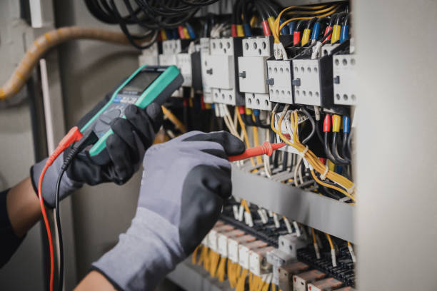 istock Electricity and electrical maintenance service, Engineer hand holding AC multimeter checking electric current voltage at circuit breaker terminal and cable wiring main power distribution board. 1415976601