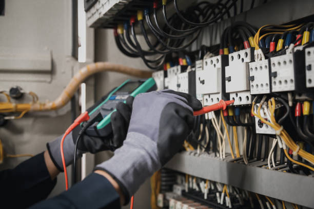 istock Electricity and electrical maintenance service, Engineer hand holding AC multimeter checking electric current voltage at circuit breaker terminal and cable wiring main power distribution board. 1415976615