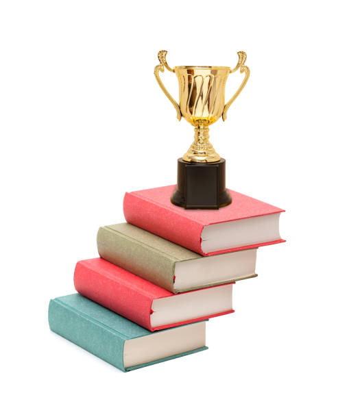 istock Trophy  on the book stairs isolated on white background 1415977231