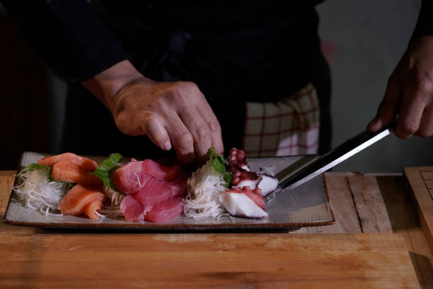 close-up of a japanese chef preparing to cook japanese food. make sushi at a traditional japanese restaurant on a chopping board. - buffet japanese cuisine lifestyles ready to eat imagens e fotografias de stock