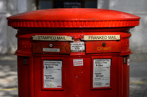Royal Mail logo on a red vintage mailbox during talks of strikes for pay rise