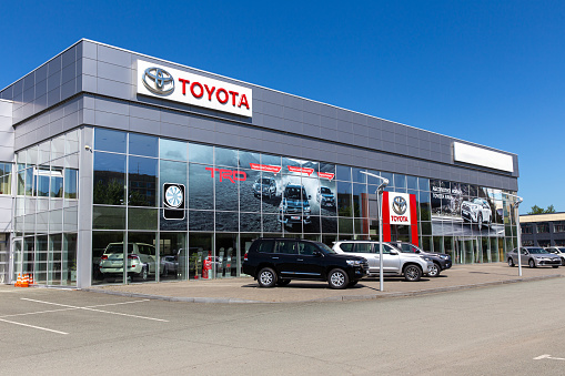 Tokyo, Japan - June 04, 2021: Toyota dealership with modern facade and cars on display in front of the retail cente