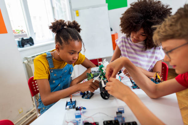 bambini studenti che costruiscono auto robotiche alla classe stem - child building activity construction engineer foto e immagini stock