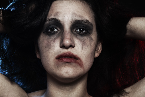 sad woman with smeared make up in dark