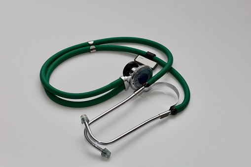 Medical stethoscope on a white background. Green stethoscope - product photo. Doctor's stethoscope isolated