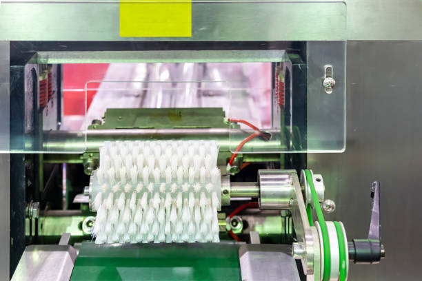 istock White pp roller brush on machine over bent conveyor component for cleaning product before next process such as contain and packing in food industrial or other 1415994332