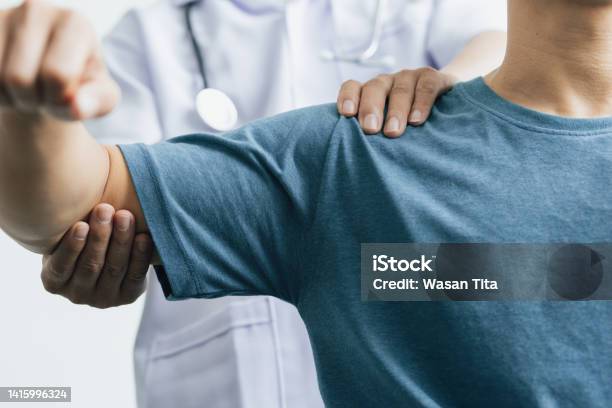 A Man With Shoulder Pain Goes To The Doctor The Doctor Diagnoses The Patients Arm Pain And Shoulder Pain Concept Of Physical Therapy And Rehabilitation Stock Photo - Download Image Now