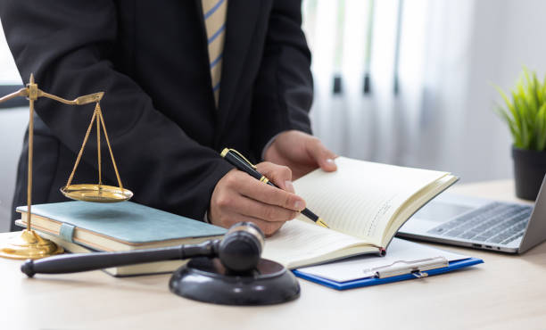 istock Legal counsel is writing a note on a notepad while working in a lawyer's office. 1415996990