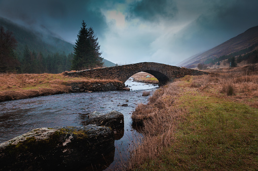 Bridge over a small river in Scotland with moody a sky