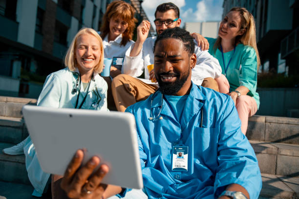 istock Happy Multiethnic doctors in clinic park using internet connection with friends 1415998723