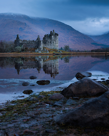 Reflection of kilchurn castle from the waters edge of loch awe