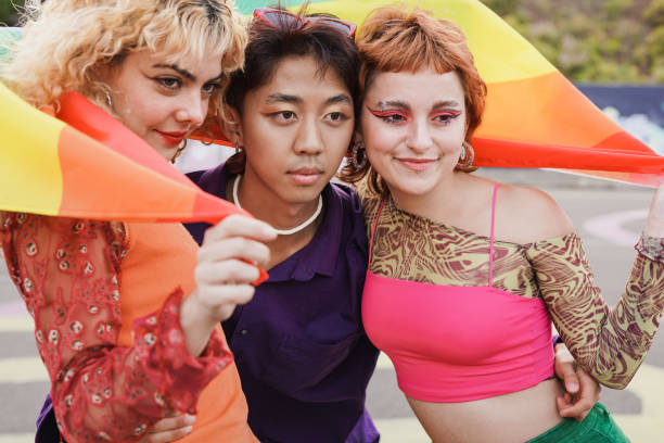 istock Young diverse friends having fun with LGBT rainbow flag at pride parade 1416001704