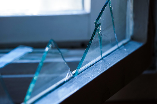 Broken security glass that once covered the window of a security checkpoint, now abandoned.  Belfast Northern Ireland.