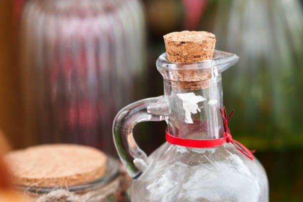 istock Old glass bootle with cork cap and glass handle on ancient glass bootles background 1416003830