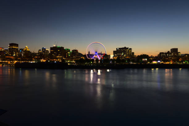 Long exposure of Montreal Downtown skyline during the twilight blue hour with motion blur of Montreal Grand Ferris Wheel stock photo