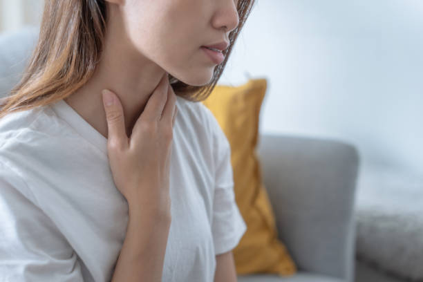 donna asiatica che soffre di mal di gola, reflusso acido. - lymph node foto e immagini stock