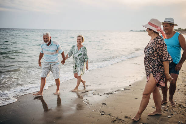 istock Mature couples walking on the beach 1416008656