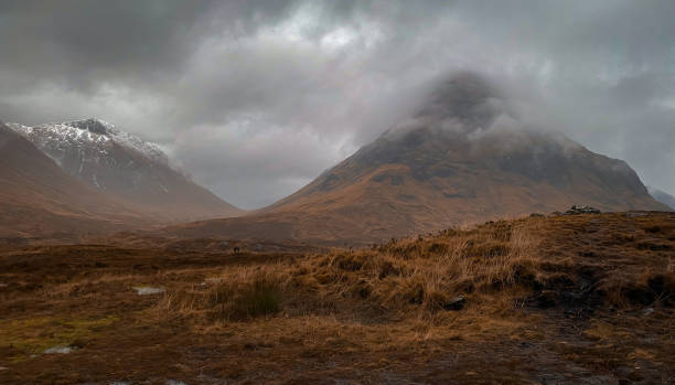 Clouds around top of Glen Coe Scotland Clouds at the top of Glen Coe with snow capped mountains in the Scottish highlands argyll and bute stock pictures, royalty-free photos & images