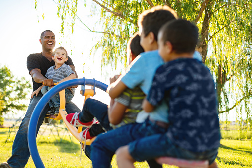 African American Happy Families in Western USA Children Playing on Seesaw Spending Quality Time Together with Young Adult Father Photo Series