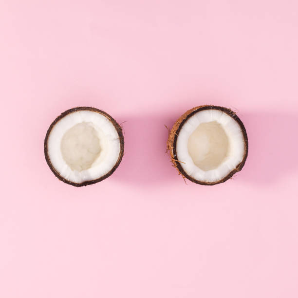 istock One coconut broken in two peaces on pastel pink background. Flat lay 1416016270