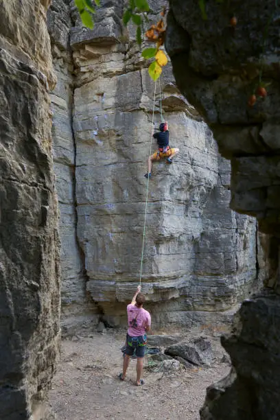 Teenage girl in a difficult rock climbing, secured by her dad in the rock gardens of Hessigheim, Neckar valley, Baden-Wuerttemberg, Germany