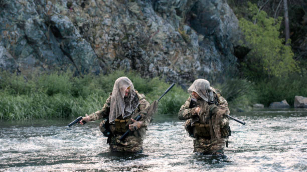 istock Two mercenary soldiers ford a river during a special operation. 1416018101