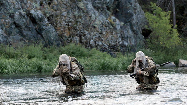 istock Two mercenary soldiers ford a river during a special operation. 1416018113