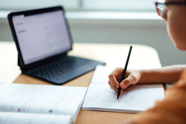 istock Portrait of an Unrecognizable Boy Using His Tablet to Do Homework at Home 1416018478