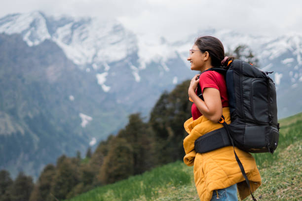 adolescente indienne en randonnée en montagne avec sac à dos à manali, himachal pradesh, inde. randonneuse profitant d’une vue idyllique sur la chaîne de montagnes de l’himalaya. activité de voyage et d’aventure - himachal photos et images de collection