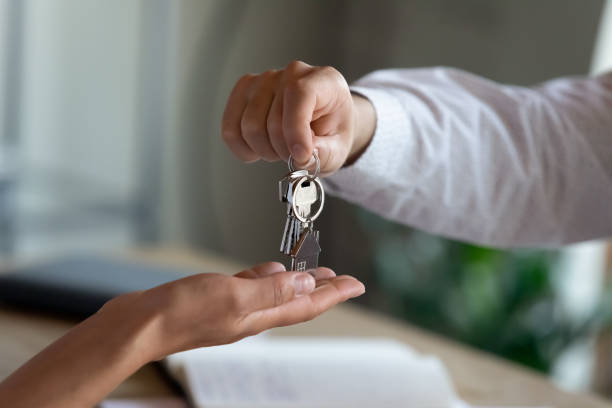 Close up professional Real estate agent giving keys to client. stock photo