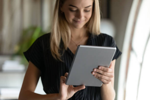 istock Smiling attractive young businesswoman using touchpad in office. 1416019235