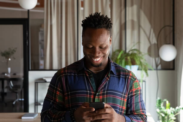 istock Smiling young african man using cellphone applications. 1416019259