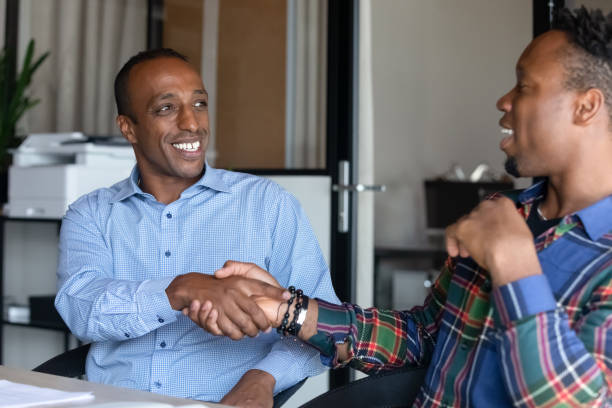 istock Smiling african manager shaking hands with colleague. 1416019260
