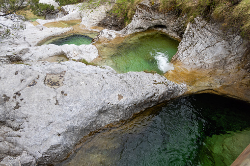 Natural path of Val Falcina at Valle del Mis in Italy. Cadini of Brenton, Sospirolo, with blue azure clear water and multiple waterfalls along the way down