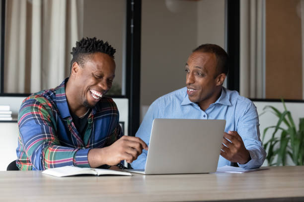 istock Happy african american male employees working on computer. 1416019616