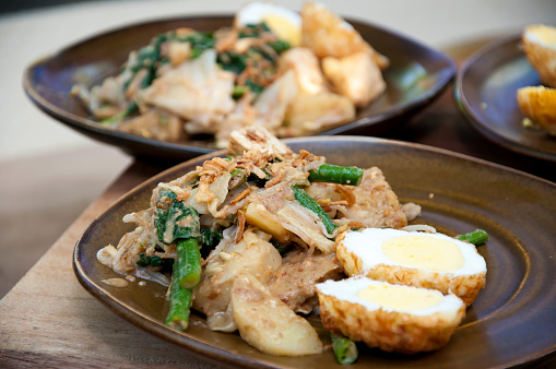 Jukut Urap, a popular traditional Balinese street food vegetable salad with ingredients like cooked spinach, boiled egg, long beans, bean sprouts mixed with spicy grated coconut.
