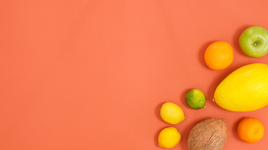 Creative copy space with citrus fruits on dark orange background. Flat lay