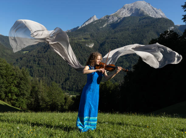 joven violinista tocando el violín en los alpes - spaciousness fotografías e imágenes de stock
