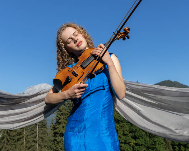 istock Young violinist playing against the sky 1416025051