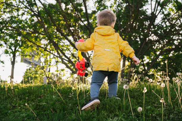 istock Rear view of active toddler boy walking outdoors in spring. 1416031567