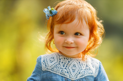 Eight year old girl with her red hair photographed against a white background.