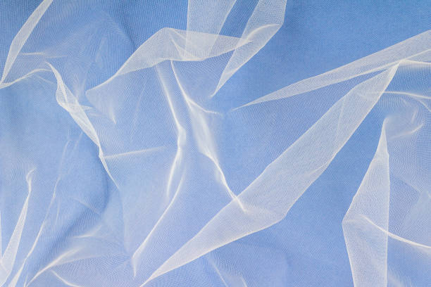 istock sheer tulle fabric arranged in soft folds on a blue background, selective focus 1416033120
