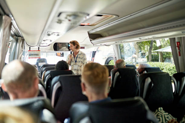 guide standing at front of coach and talking to passengers - bus coach bus travel tour bus imagens e fotografias de stock
