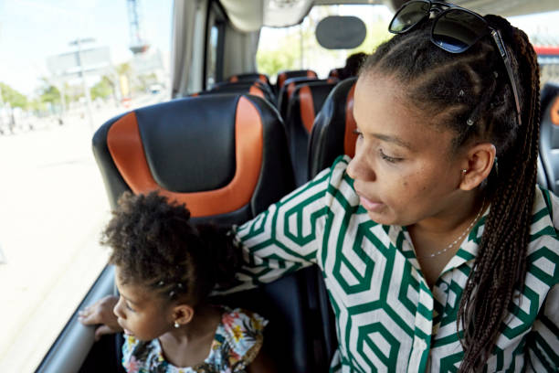 istock Mother and daughter looking through window on coach 1416033347