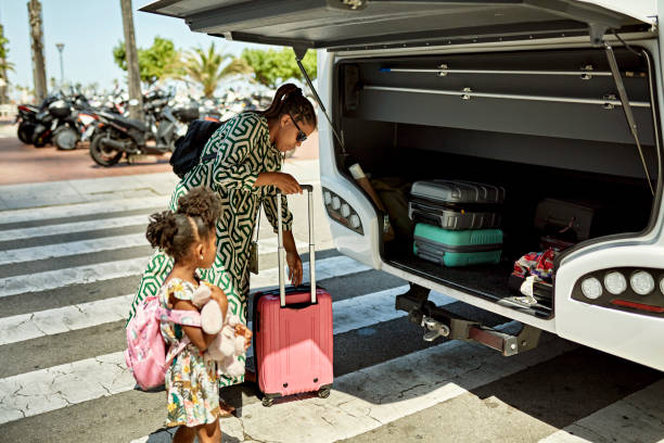 famiglia nera che carica i bagagli nel deposito sul retro dell'autobus - trolley bus foto e immagini stock