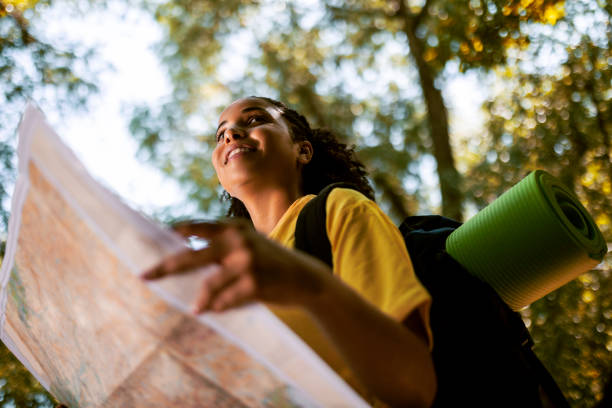 istock Woman hiking in nature looking at map 1416034414