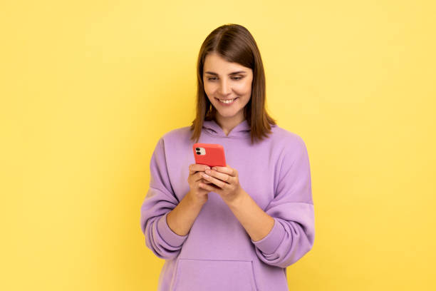 istock Woman reading message on smartphone and smiling, using mobile device for communication. 1416036969
