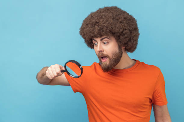istock Man looking through magnifying glass, spying, finding out something, exploring crime scene. 1416037618