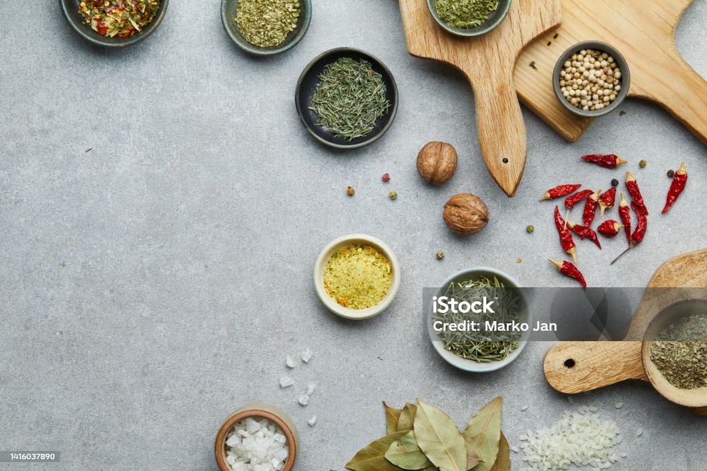 Spice and seasoning on a wooden cutting boards Spice and seasoning in a small handmade ceramic bowls, on a wooden cutting boards, on a gray granite table top, top view concept with a large copy space for text Spice Stock Photo