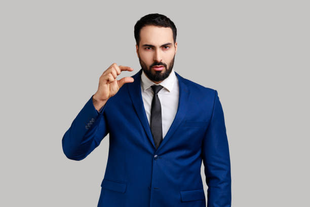 istock Man looking disappointed and showing a little bit gesture, small amount or low scale sign. 1416037929